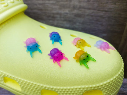 A vibrant collection of beetle-themed shoe charms decorates a yellow shoes shoe. The charms feature detailed, multicolored beetles in various shades, adding a playful yet nature-inspired vibe to the footwear.
