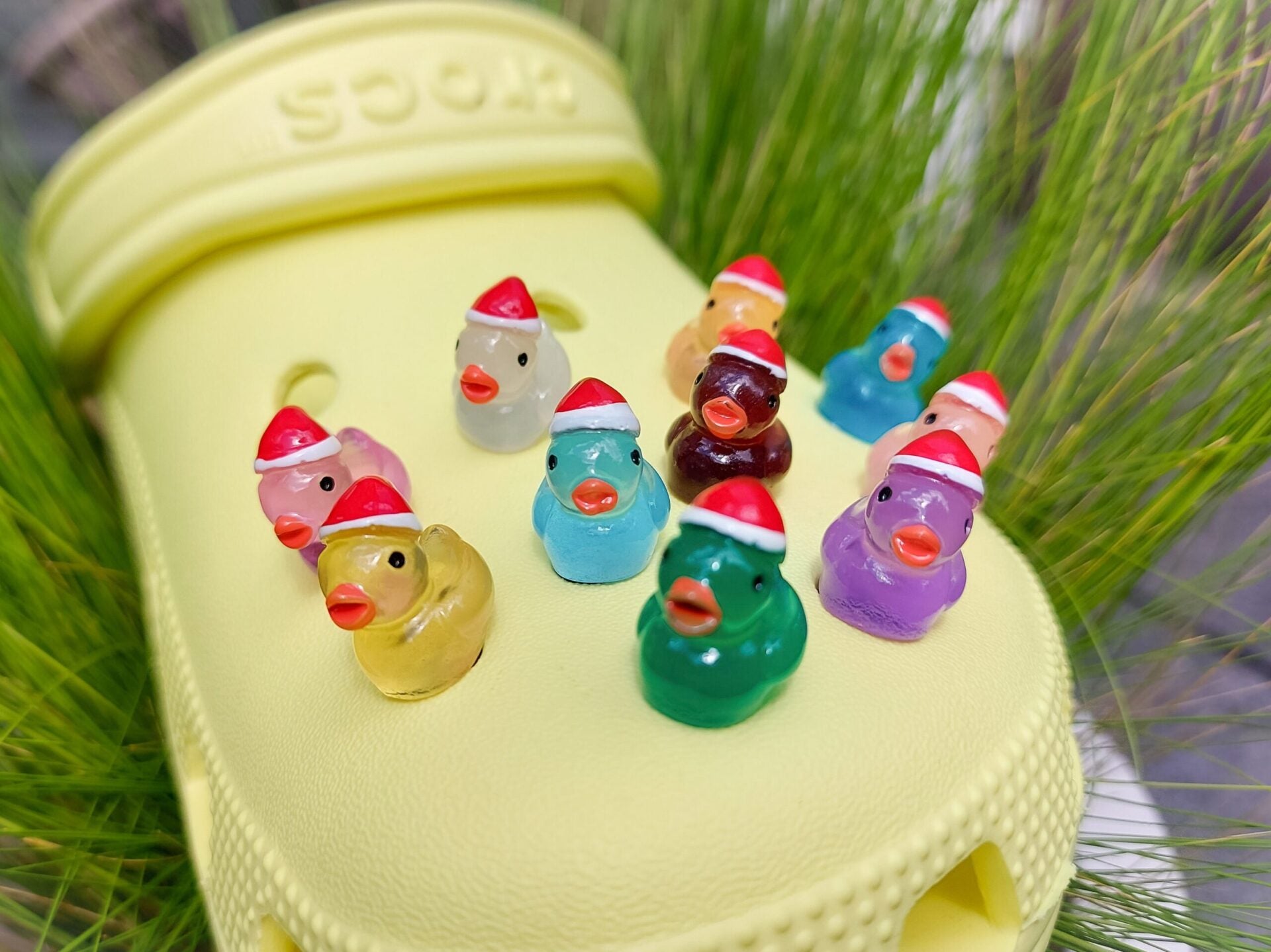 Glow-in-the-dark duck charms wearing Santa hats on a pair of shoes shoes. These festive and luminous accessories add a playful, holiday-themed touch to your footwear, perfect for customizing your shoes with a unique, glowing Christmas spirit.