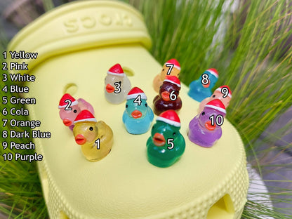Glow-in-the-dark duck charms wearing Santa hats on a pair of shoes shoes. These festive and luminous accessories add a playful, holiday-themed touch to your footwear, perfect for customizing your shoes with a unique, glowing Christmas spirit.