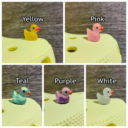 Glow in the dark duck shoe charms on a pair of shoes shoes. The ducks resemble a rubber bath duckie.