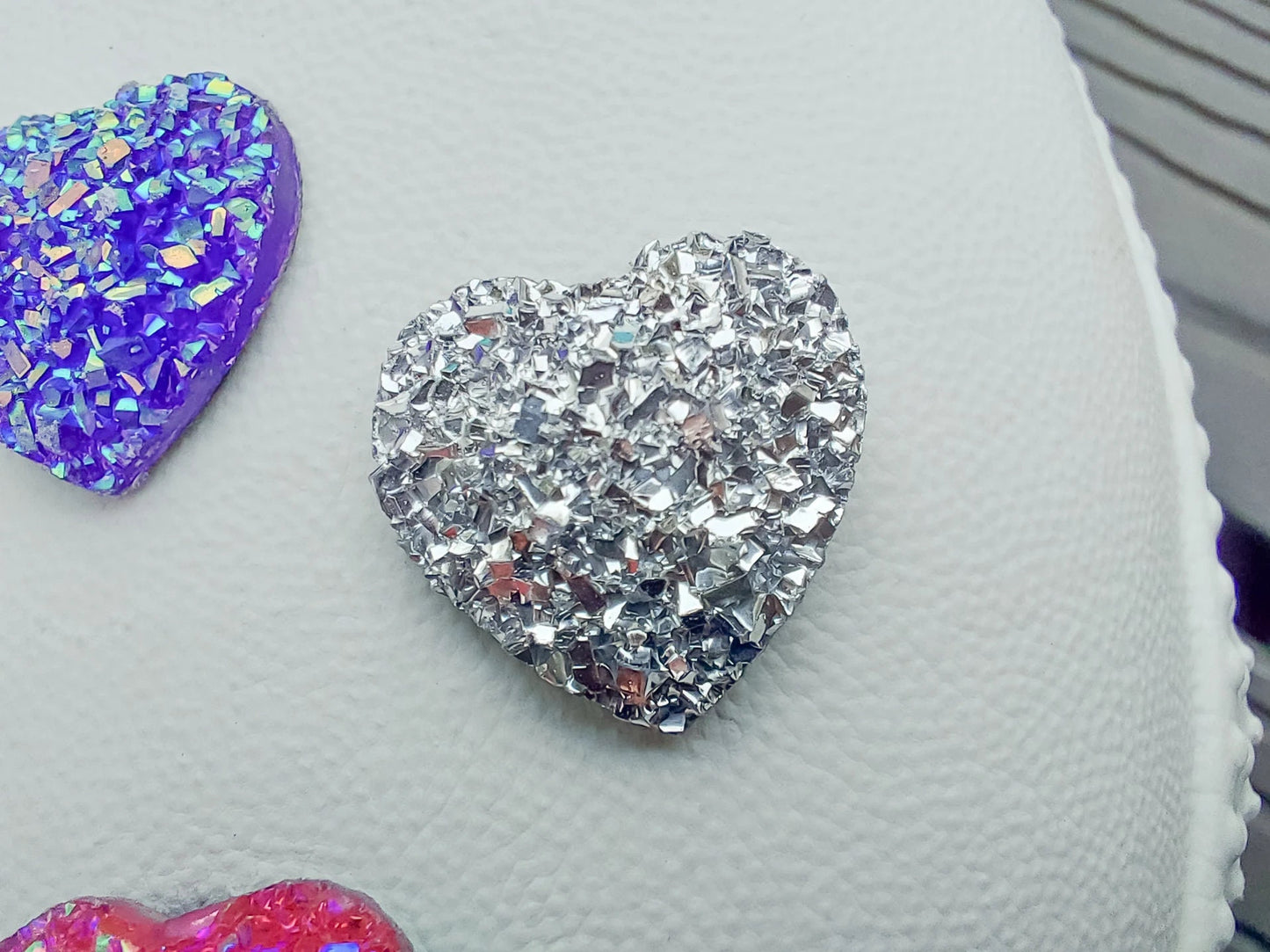 Sparkly and glittery rhinestone shoe charms in heart shapes on a pair of shoes shoes. Different colors such as silver, gold, rose, jade, amethyst, diamond.