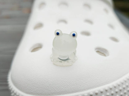 Glow-in-the-dark frog charms on a shoe shoe. These playful and luminous accessories add a fun, froggy touch to your footwear, making them perfect for customizing your shoes with a whimsical and adventurous vibe.