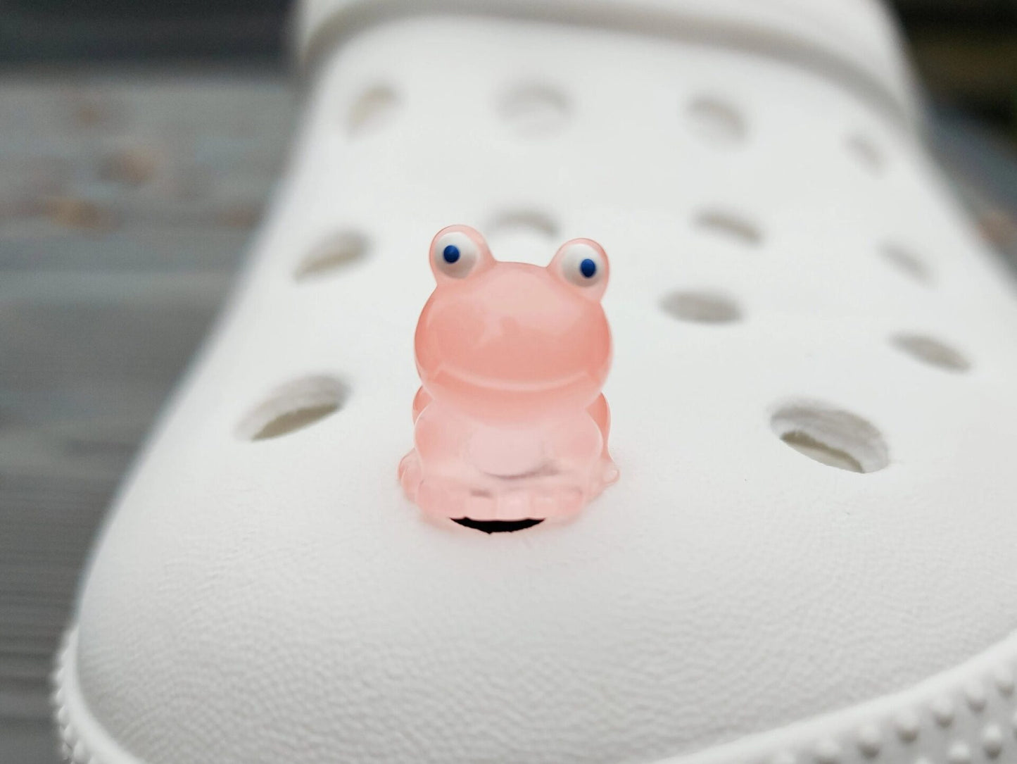 Glow-in-the-dark frog charms on a shoe shoe. These playful and luminous accessories add a fun, froggy touch to your footwear, making them perfect for customizing your shoes with a whimsical and adventurous vibe.