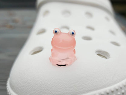 Glow-in-the-dark frog charms on a shoe shoe. These playful and luminous accessories add a fun, froggy touch to your footwear, making them perfect for customizing your shoes with a whimsical and adventurous vibe.