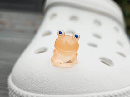 Glow-in-the-dark frog charms on a shoe shoe. These playful and luminous accessories add a fun, froggy touch to your footwear, making them perfect for customizing your shoes with a whimsical and adventurous vibe.