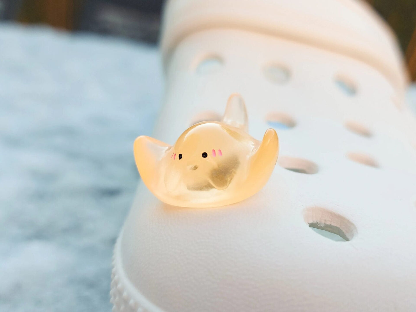Glow-in-the-dark manta ray charms on a shoe shoe. These enchanting accessories light up in the dark, adding a marine-inspired touch to your footwear. Perfect for customizing your shoes with a unique and magical ocean theme.