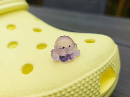 Glow in the dark octopus shoe charms on a pair of shoes shoes. Luminous charms in different colors.