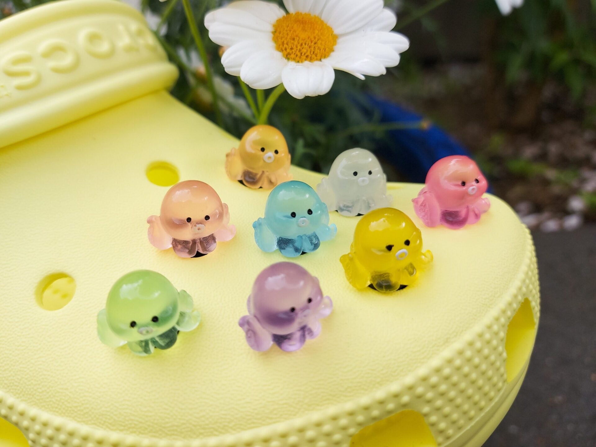 Glow in the dark octopus shoe charms on a pair of shoes shoes. Luminous charms in different colors.