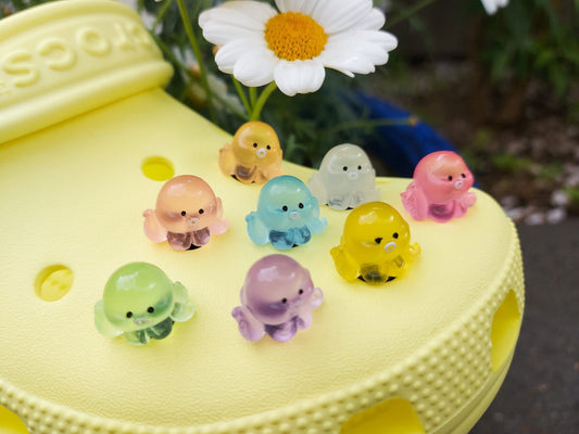 Glow in the dark octopus shoe charms on a pair of shoes shoes. Luminous charms in different colors.