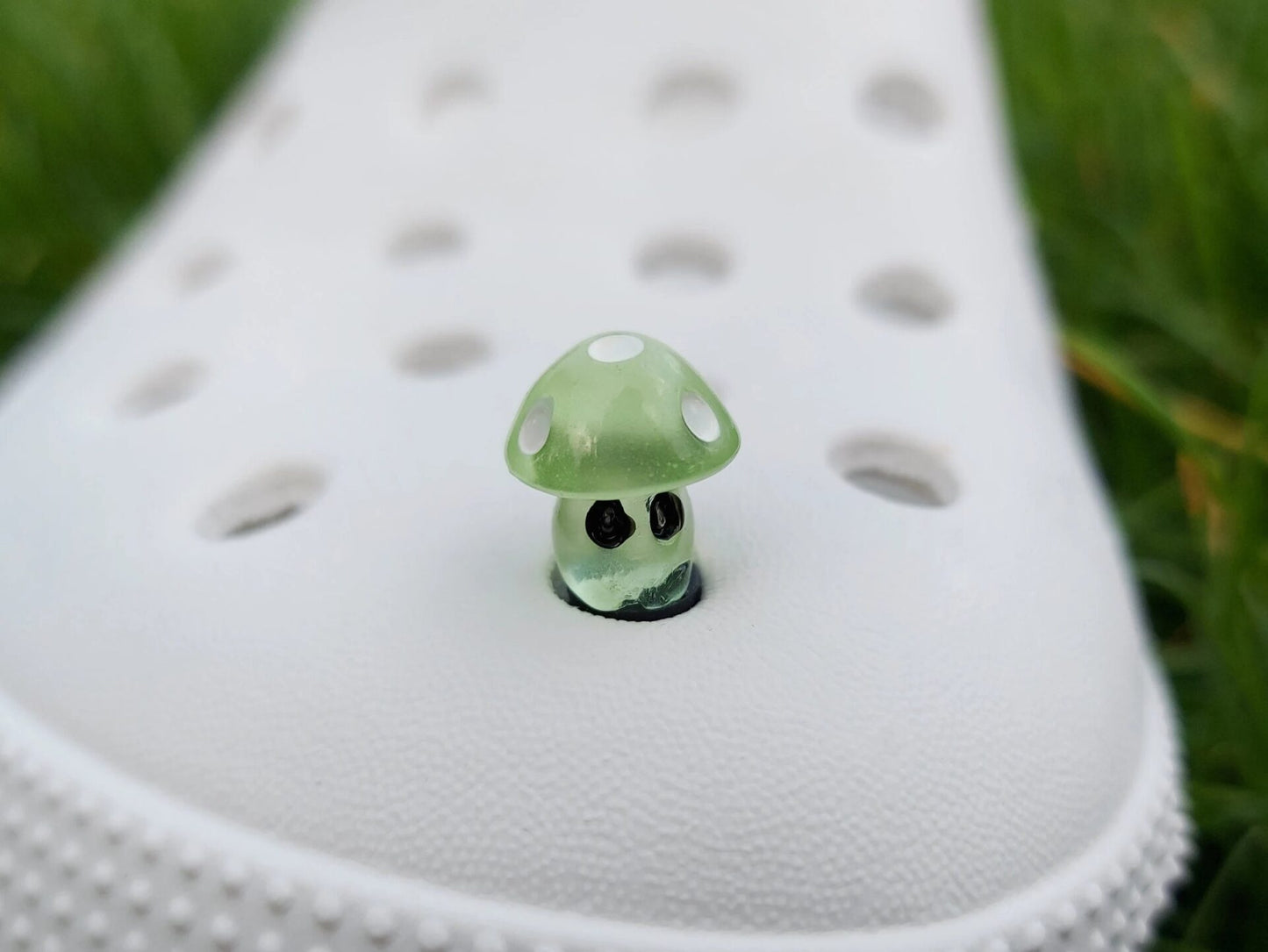 Glow-in-the-dark mushroom charms on a pair of shoes shoes. These luminous accessories add a magical, whimsical touch to your footwear, perfect for customizing with a unique forest-inspired design that glows beautifully in the dark.