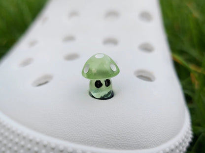 Glow-in-the-dark mushroom charms on a pair of shoes shoes. These luminous accessories add a magical, whimsical touch to your footwear, perfect for customizing with a unique forest-inspired design that glows beautifully in the dark.