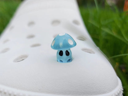 Glow-in-the-dark mushroom charms on a pair of shoes shoes. These luminous accessories add a magical, whimsical touch to your footwear, perfect for customizing with a unique forest-inspired design that glows beautifully in the dark.