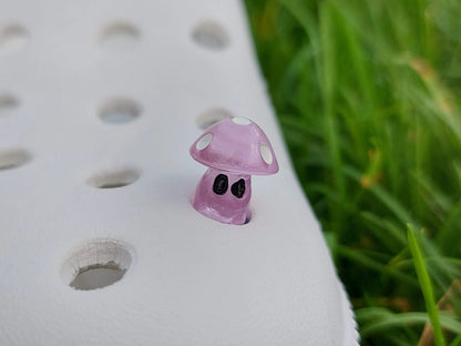 Glow-in-the-dark mushroom charms on a pair of shoes shoes. These luminous accessories add a magical, whimsical touch to your footwear, perfect for customizing with a unique forest-inspired design that glows beautifully in the dark.