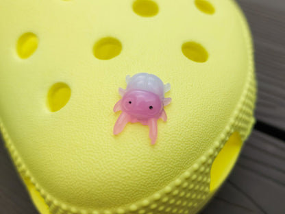 A vibrant collection of beetle-themed shoe charms decorates a yellow shoes shoe. The charms feature detailed, multicolored beetles in various shades, adding a playful yet nature-inspired vibe to the footwear.