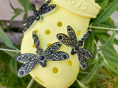 3D-printed glow-in-the-dark dragonfly charm with a Celtic weave pattern on a shoe shoe. The intricate design adds a whimsical and enchanting touch to the footwear, perfect for day or night style.