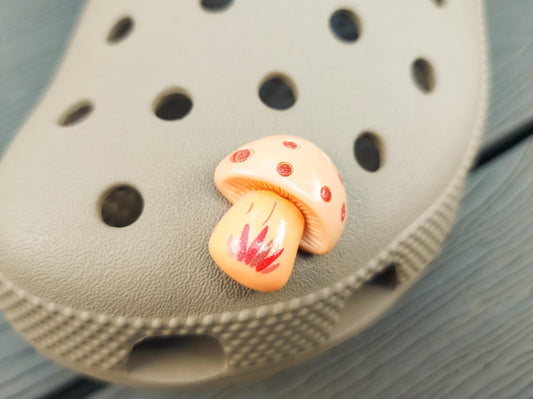 Close-up of forest mushroom charms on a shoe shoe, featuring detailed mushroom designs. The charms are securely attached, adding a whimsical, woodland touch to the shoe with a vibrant, nature-inspired look.