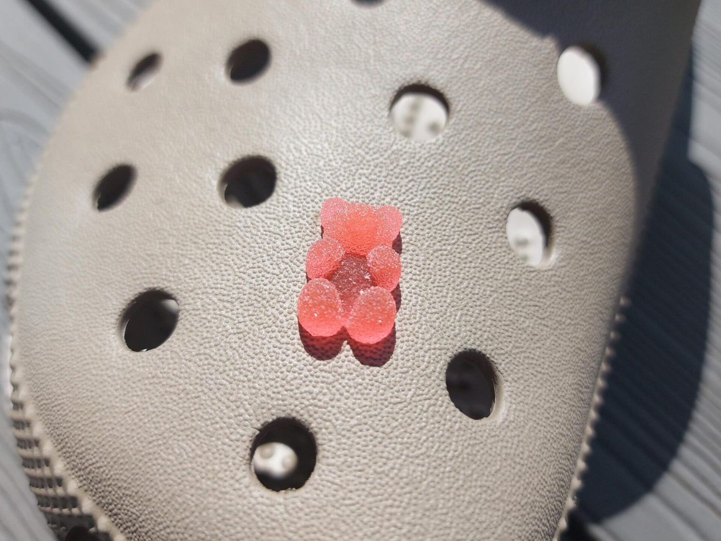 Close-up of sugar gummy bear charms on a shoe shoe, featuring bright, colorful gummy bear designs. The charms are securely attached, adding a playful, candy-inspired touch to the shoe with a fun and vibrant look.