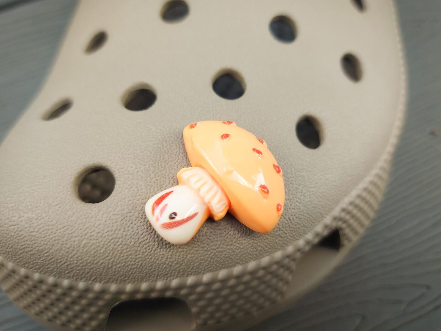 Close-up of forest mushroom charms on a shoe shoe, featuring detailed mushroom designs. The charms are securely attached, adding a whimsical, woodland touch to the shoe with a vibrant, nature-inspired look.