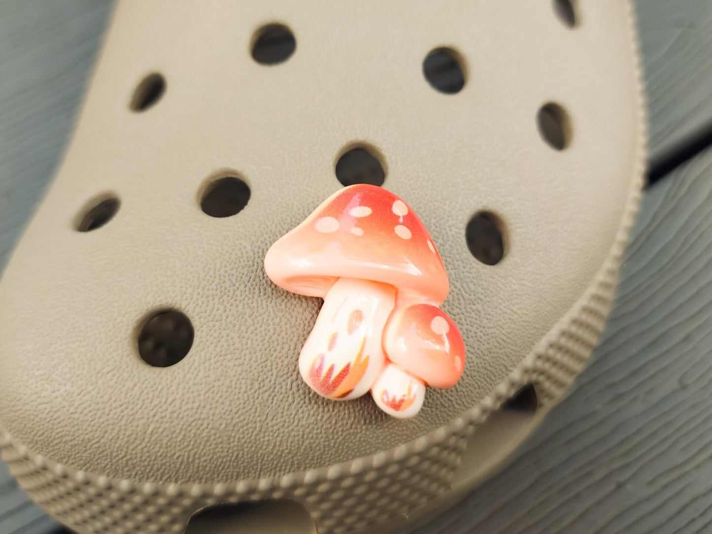 Close-up of forest mushroom charms on a shoe shoe, featuring detailed mushroom designs. The charms are securely attached, adding a whimsical, woodland touch to the shoe with a vibrant, nature-inspired look.