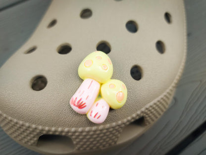 Close-up of forest mushroom charms on a shoe shoe, featuring detailed mushroom designs. The charms are securely attached, adding a whimsical, woodland touch to the shoe with a vibrant, nature-inspired look.