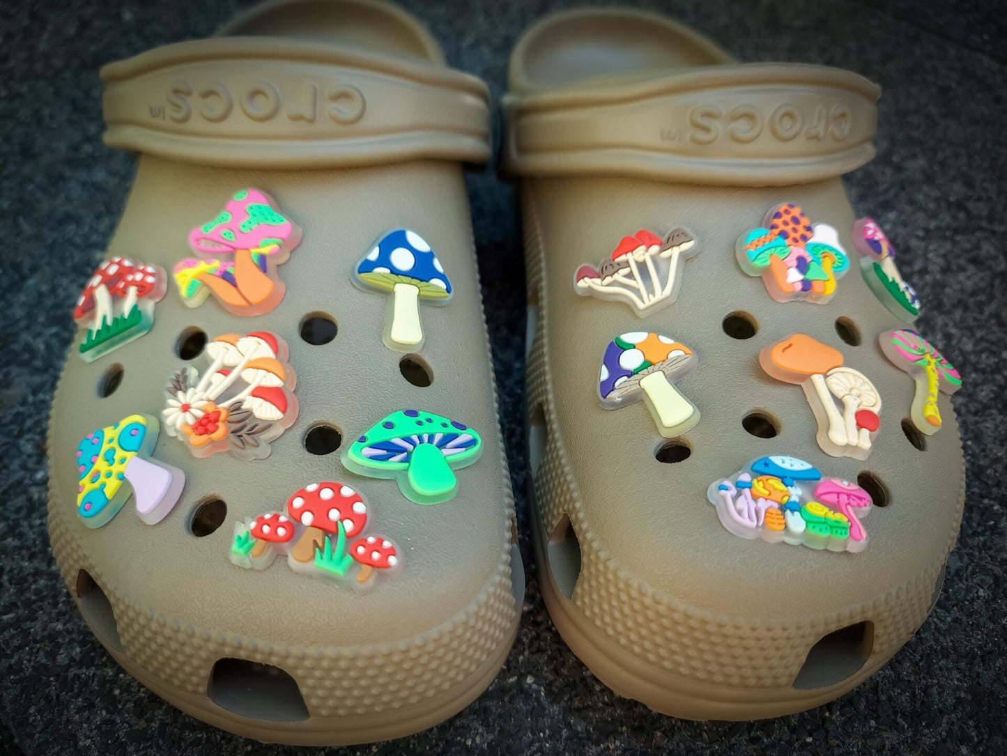 Close-up of beige shoes featuring glow-in-the-dark neon mushroom charms in vibrant colors like green, pink, and orange. The luminous mushrooms stand out against the shoes, creating a playful and eye-catching effect.
