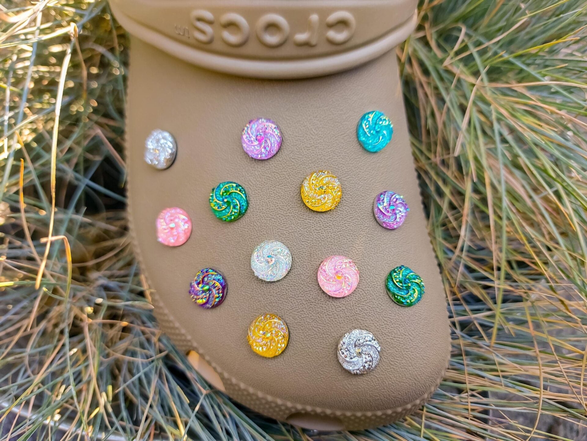 Colorful crystal round charms with sparkly rhinestones on a brown shoe shoe. These vibrant and glittering accessories add a dazzling touch to your footwear, perfect for customizing your shoes with a unique and eye-catching sparkle.