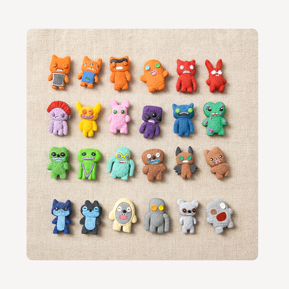 A set of colorful monster and creature clog charms arranged in rows on a square beige fabric background.