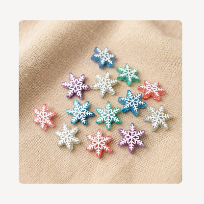 A group of small snowflake-shaped clog charms in assorted pastel and bright colors, arranged on a beige textured fabric background.