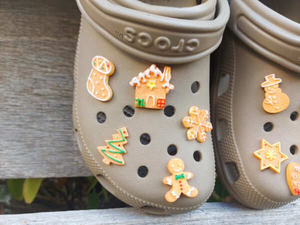 A collection of gingerbread-themed Croc charms shaped like Christmas trees, snowflakes, and stars, each with a realistic cookie appearance. These festive charms add a cozy, holiday-inspired touch to your footwear.