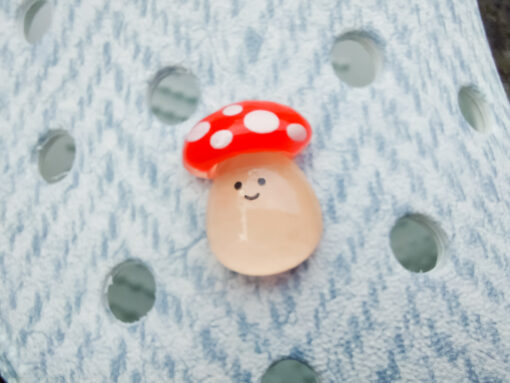 Close-up of a shoe decorated with a 5-piece jelly charm set, including two flowers, a yellow duck, a bunny with a pink bow, and a red mushroom. Each charm has a cute, soft, jelly-like appearance, adding a fun and playful vibe to the footwear.