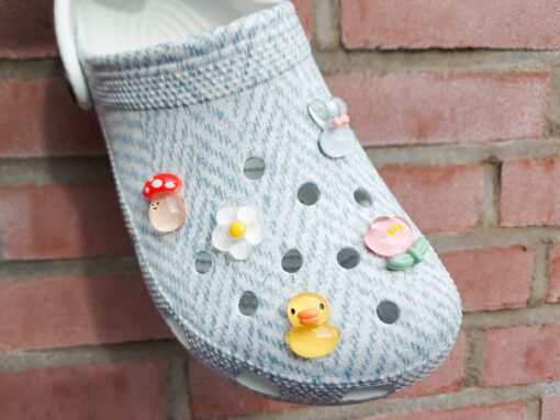Close-up of a shoe decorated with a 5-piece jelly charm set, including two flowers, a yellow duck, a bunny with a pink bow, and a red mushroom. Each charm has a cute, soft, jelly-like appearance, adding a fun and playful vibe to the footwear.
