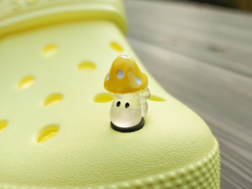 Glow-in-the-dark wild mushroom charms on a Croc shoe. These whimsical accessories light up in the dark, adding a magical and nature-inspired touch to your footwear. Perfect for customizing your Crocs with a unique forest theme.
