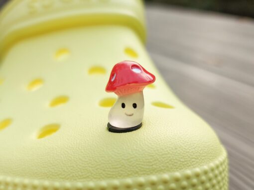 Glow-in-the-dark wild mushroom charms on a Croc shoe. These whimsical accessories light up in the dark, adding a magical and nature-inspired touch to your footwear. Perfect for customizing your Crocs with a unique forest theme.