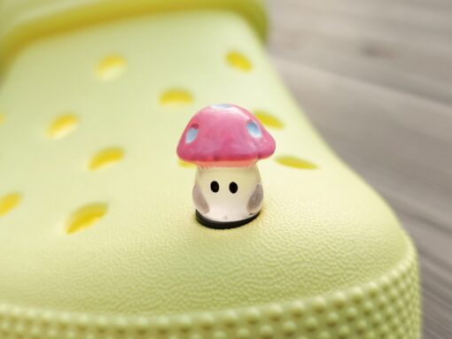 Glow-in-the-dark wild mushroom charms on a Croc shoe. These whimsical accessories light up in the dark, adding a magical and nature-inspired touch to your footwear. Perfect for customizing your Crocs with a unique forest theme.