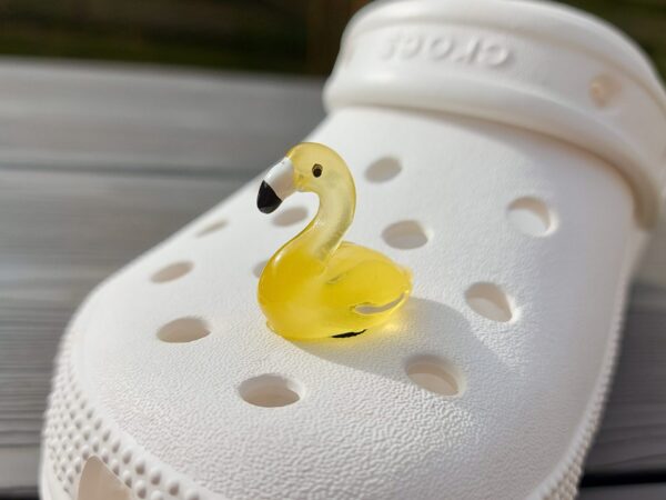 Glow in the dark flamingo shoe charms on a pair of Crocs shoes. Different colors such as pink, orange, blue, purple and green.