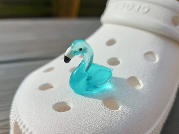 Glow in the dark flamingo shoe charms on a pair of Crocs shoes. Different colors such as pink, orange, blue, purple and green.