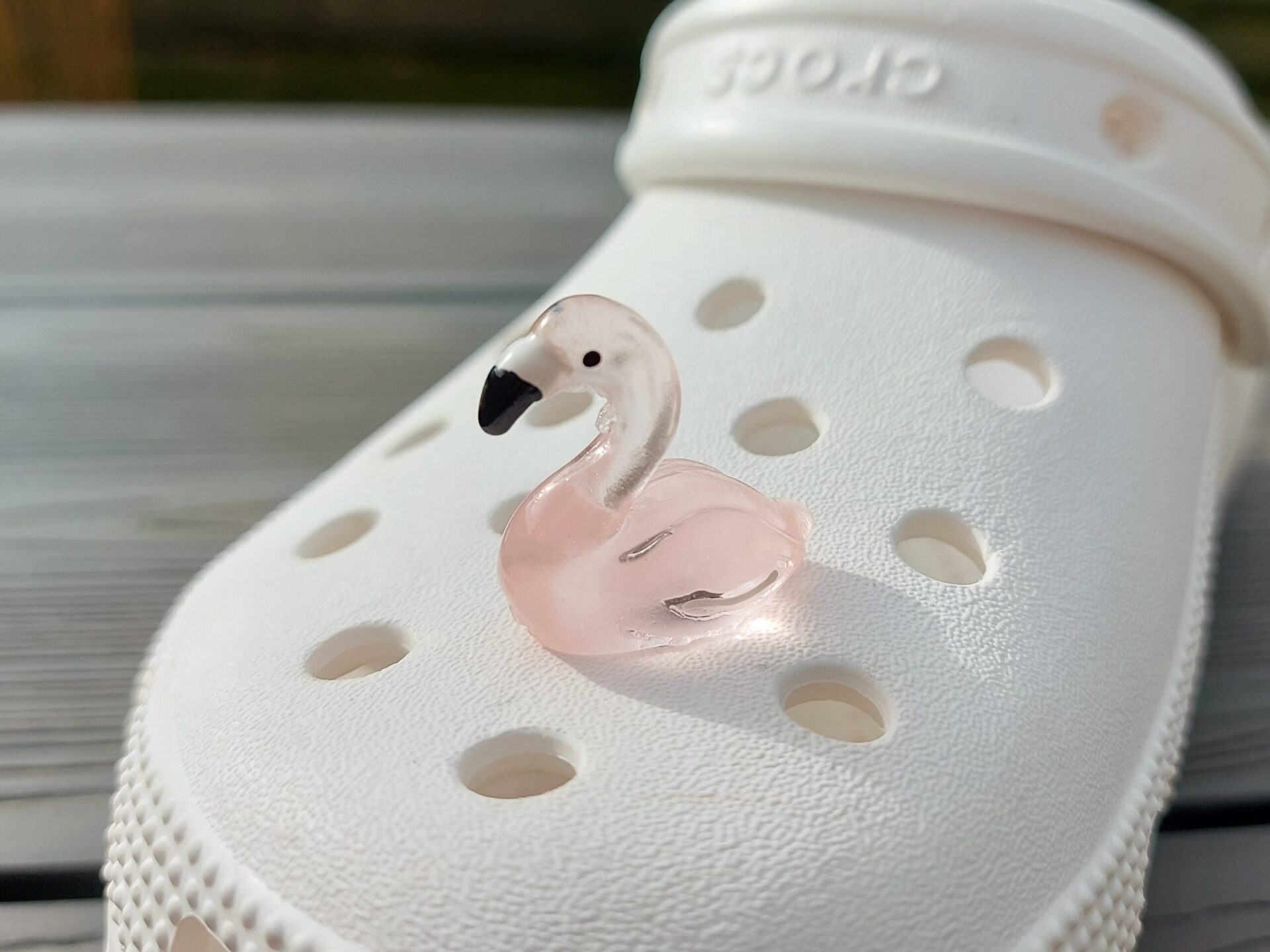 Glow in the dark flamingo shoe charms on a pair of Crocs shoes. Different colors such as pink, orange, blue, purple and green.