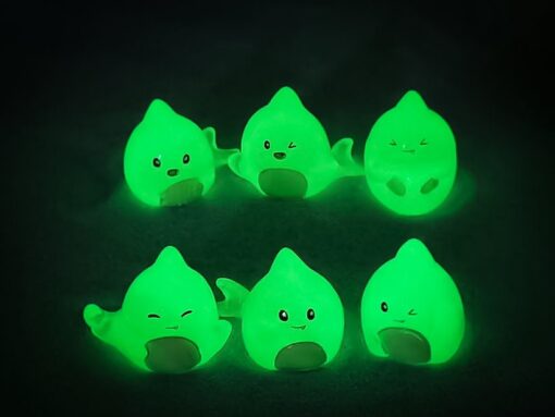 Yellow Crocs featuring cute glow in the dark shark charms, displayed against a wooden background.
