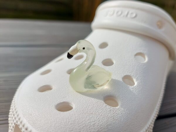 Glow in the dark flamingo shoe charms on a pair of Crocs shoes. Different colors such as pink, orange, blue, purple and green.