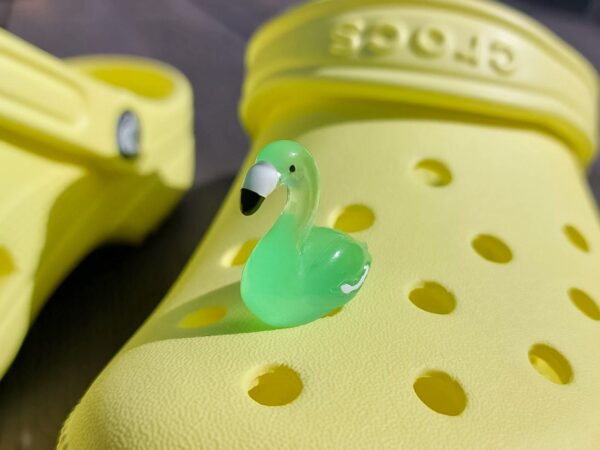 Glow in the dark flamingo shoe charms on a pair of Crocs shoes. Different colors such as pink, orange, blue, purple and green.