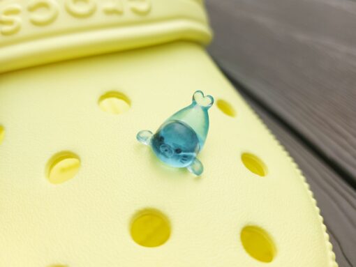 Glow in the dark seal shoe charms on a pair of Crocs shoes. The seals are made of resin and are each in different playful positions.