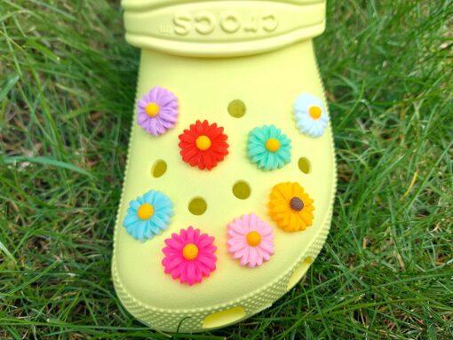 Colorful daisy flower charms on a yellow Crocs shoes. These vibrant floral charms are perfect for the spring and summer time.