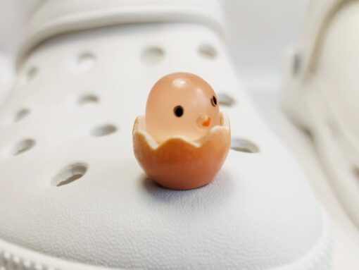 A collection of glow-in-the-dark Croc charms featuring adorable baby chicks nestled in colorful egg shells. Each charm showcases a bright chick in a variety of soft, pastel hues, perfect for adding a fun and playful glow to your Crocs at night.