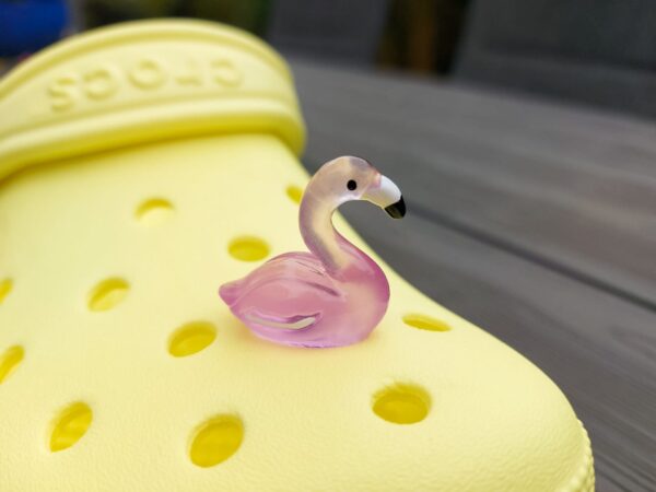 Glow in the dark flamingo shoe charms on a pair of Crocs shoes. Different colors such as pink, orange, blue, purple and green.