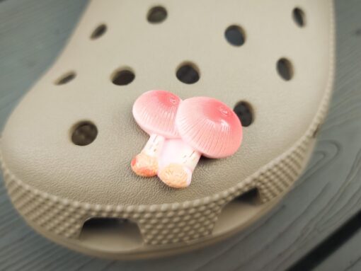 Close-up of forest mushroom charms on a Croc shoe, featuring detailed mushroom designs. The charms are securely attached, adding a whimsical, woodland touch to the shoe with a vibrant, nature-inspired look.