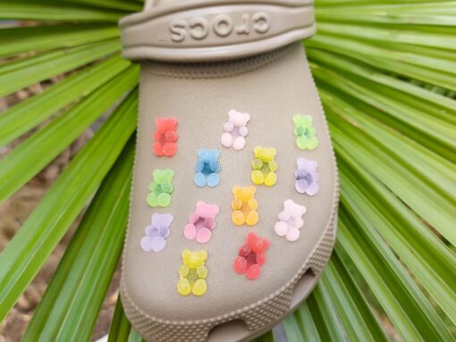 Close-up of sugar gummy bear charms on a Croc shoe, featuring bright, colorful gummy bear designs. The charms are securely attached, adding a playful, candy-inspired touch to the shoe with a fun and vibrant look.