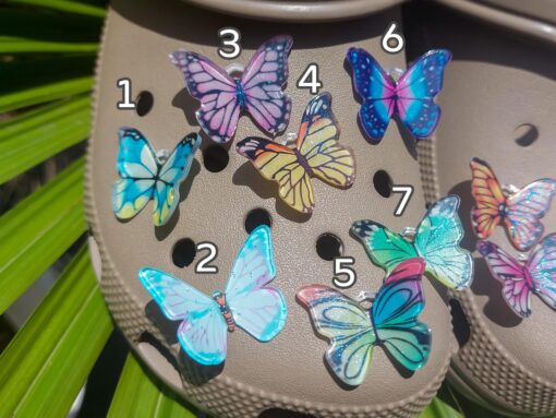 Close-up of butterfly charms on a Croc shoe, showcasing intricate butterfly designs with delicate wings. The charms are securely attached, adding a whimsical and graceful touch to the shoe with a nature-inspired, elegant look.