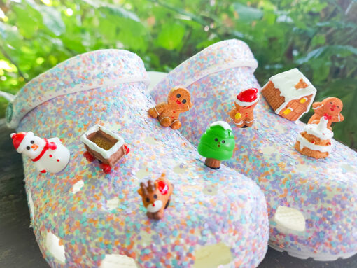 9-piece gingerbread-themed Croc charm set displayed on colorful Crocs, featuring festive characters like a snowman, reindeer, gingerbread men, a Christmas tree, and a gingerbread house, perfect for holiday decorations.
