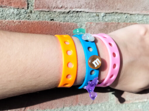 A flexible, adjustable bracelet with multiple charm slots, available in a range of vibrant colors for a personalized look.
