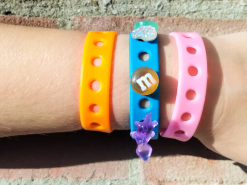 A flexible, adjustable bracelet with multiple charm slots, available in a range of vibrant colors for a personalized look.